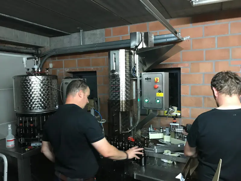 De twee brouwers aan de bottellijn
