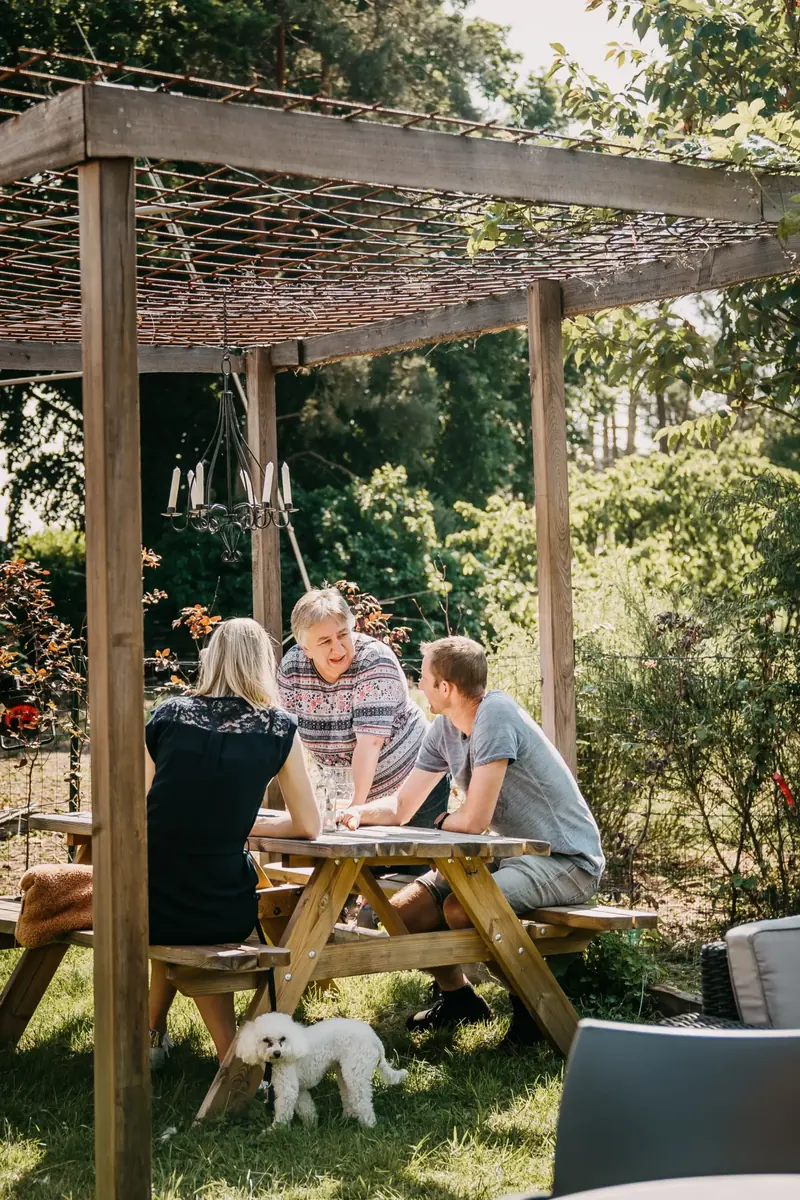 Gasten met een hondje onder de pergola